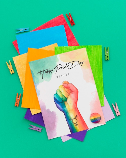 Top view of rainbow colored papers with pins and fist for lgbt pride