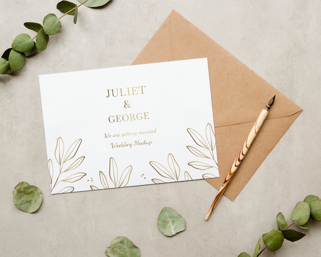 Top view of wedding card with plant and pen