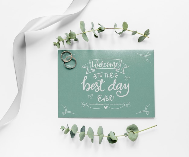 Top view of wedding card with plants and rings