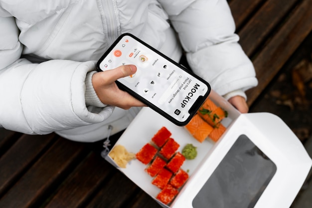 Top view woman with smartphone and sushi