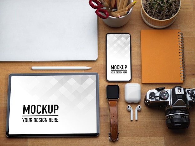 Top view of worktable with tablet, smartphone, laptop, camera and accessories