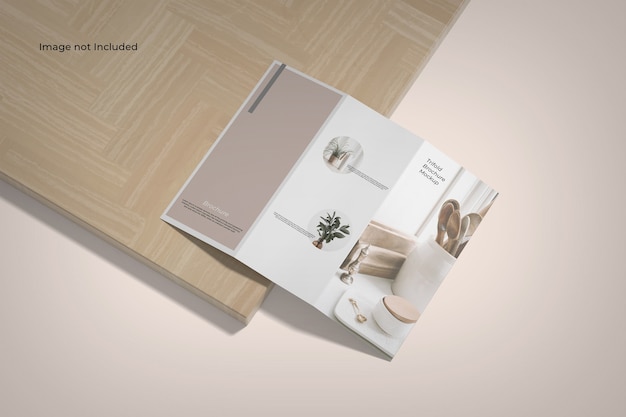 Trifold brochure mockup high angle view near a wooden board