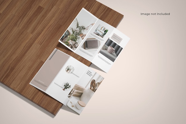 Trifold brochure mockup near a wooden board