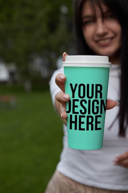 Turquoise color a large coffee cup in the girl's hand changeable color mockup psd