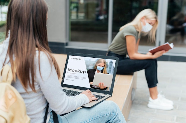 Two women keeping social distance outdoors