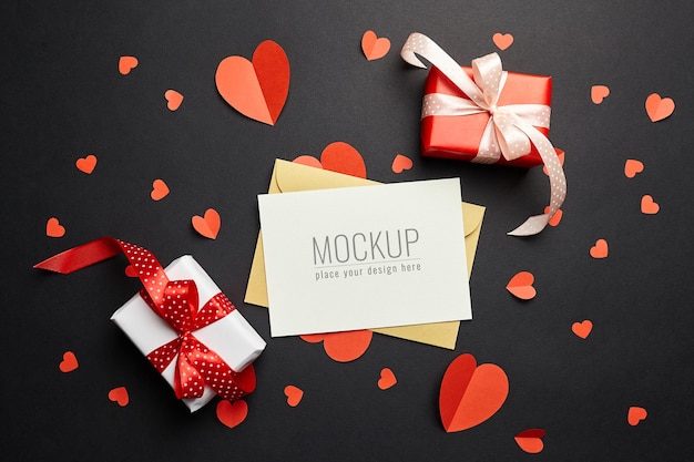 Valentines day card mockup with red paper hearts and gift boxes on black surface