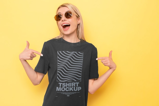 View of woman wearing t-shirt mock-up design and pointing at it