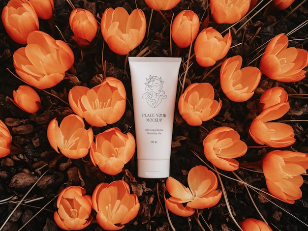 White facewash tube surrounded by orange blooming flowers