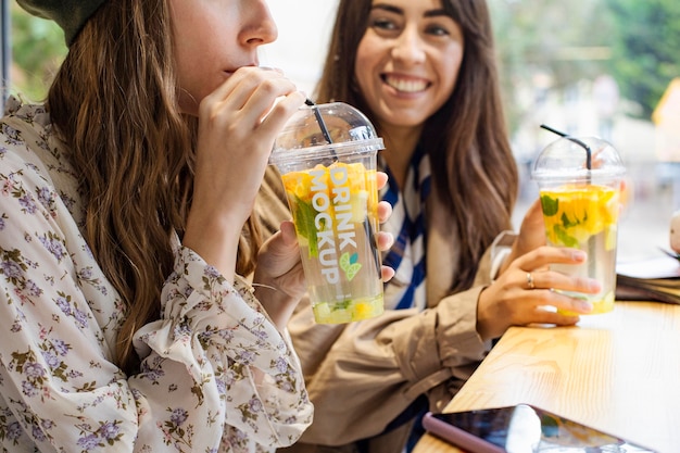 PSD woman enjoying a drink from mock-up container