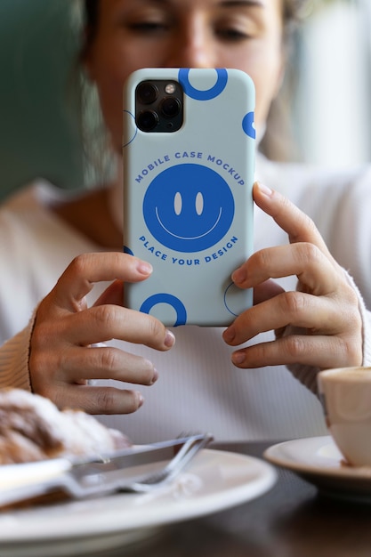 Woman hand holding smartphone mock-up indoors