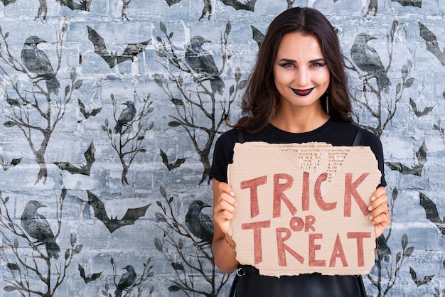 PSD woman holding a card with trick or treat lettering