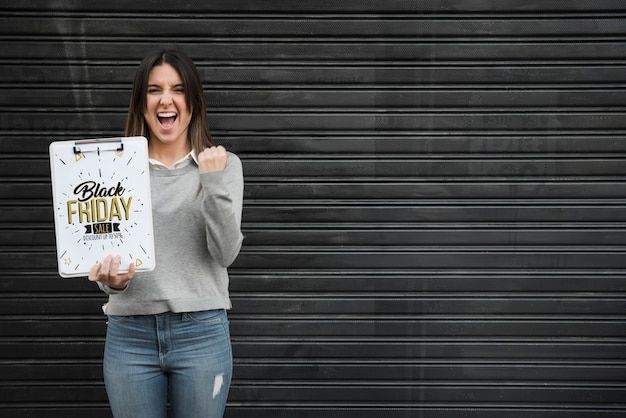 Woman holding clipboard mockup with black friday concept