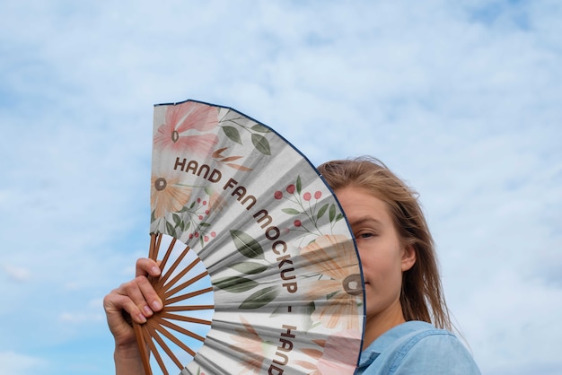 PSD woman holding hand fan with mock-up design