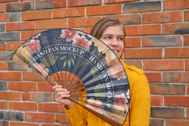 PSD woman holding hand fan with mock-up design