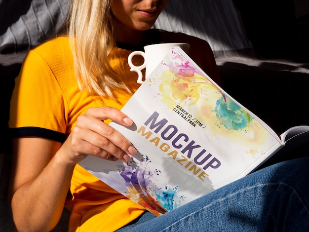 Woman holding a mock up magazine and a mug