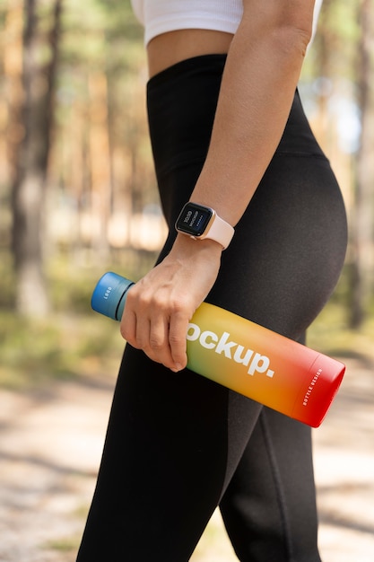 Woman holding a mock-up water bottle