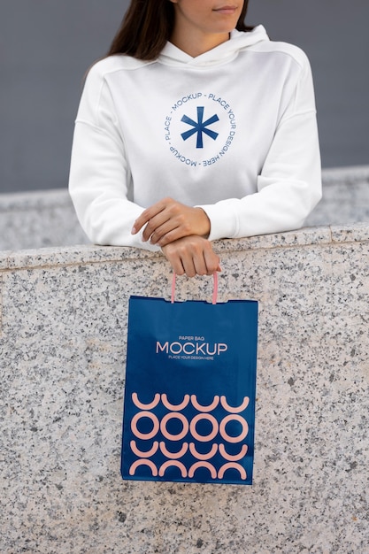 Woman holding shopping bag outdoors on the street