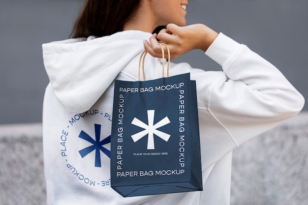 Woman holding shopping bag outdoors on the street