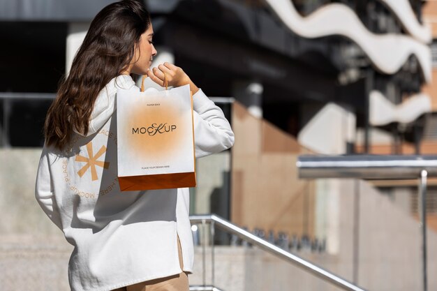 Woman holding shopping bag outdoors on the street