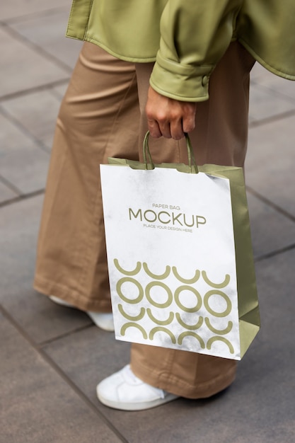 Woman holding shopping bag outdoors on the street