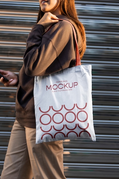 Woman holding shopping bag outdoors on the street