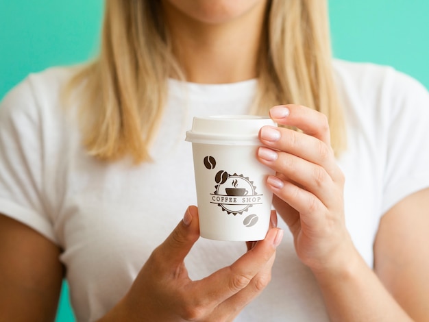 Woman holding up a coffee paper cup