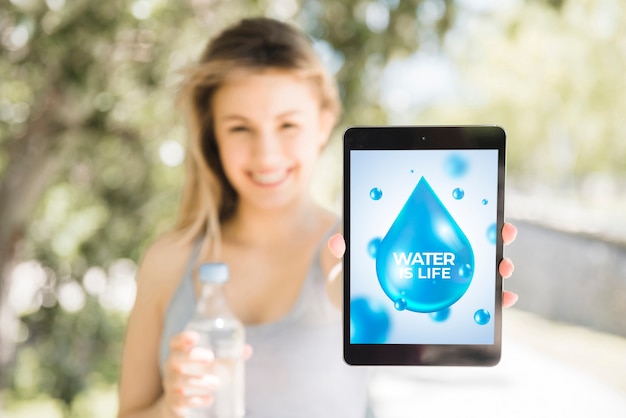 Woman presenting tablet mockup with water concept