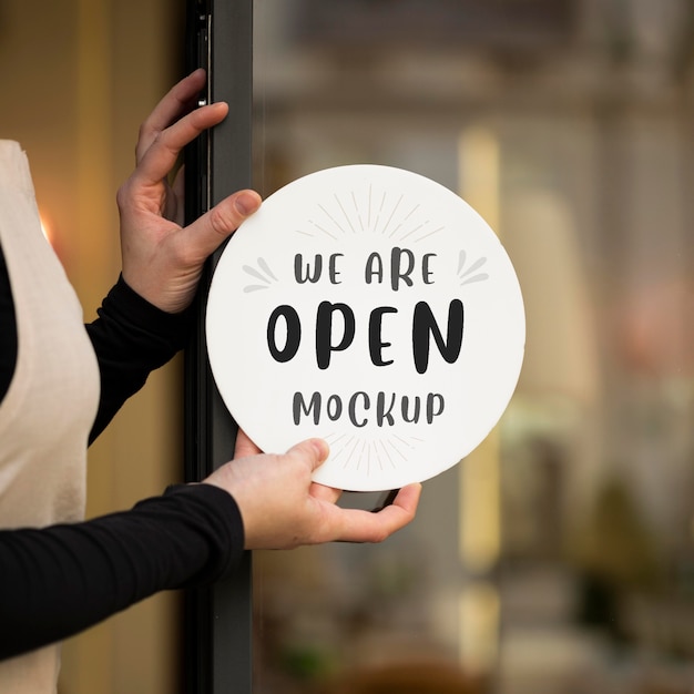 Woman showing a we are open mock-up sign