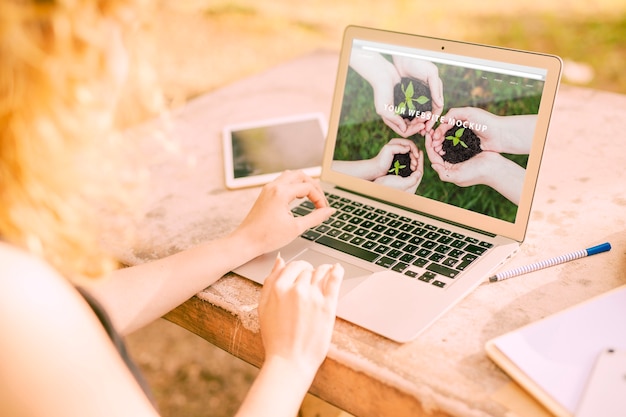 PSD woman using laptop mockup in nature