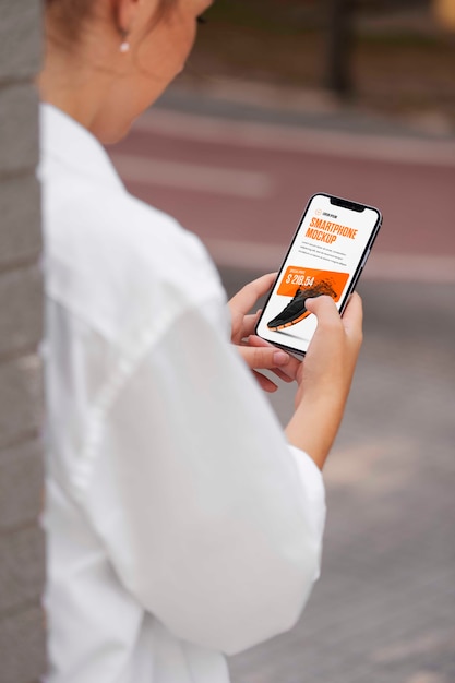 Woman using mock-up smartphone outdoors