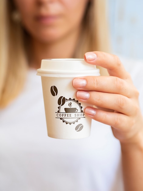 Woman wanting to drink from a coffee paper cup