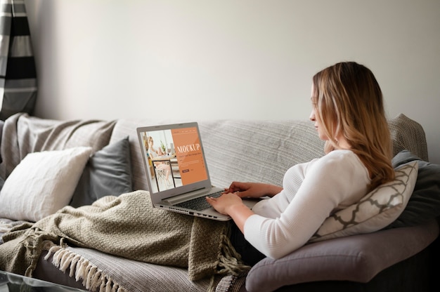 Woman working from home using laptop on the couch