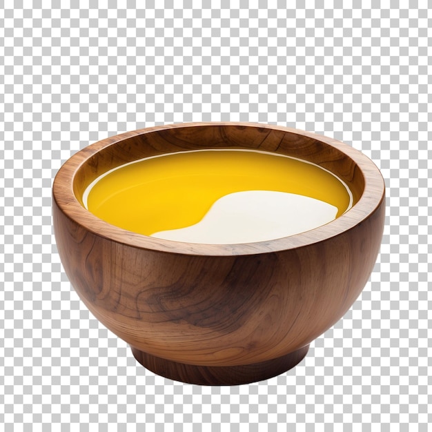 a wooden bowl with yellow liquid and spoons on it