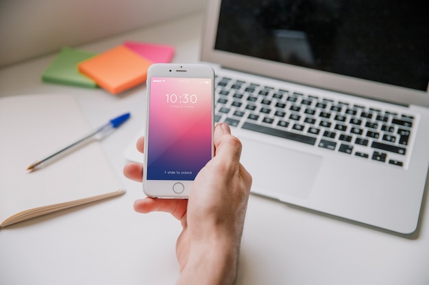 Workspace concept with hand holding smartphone