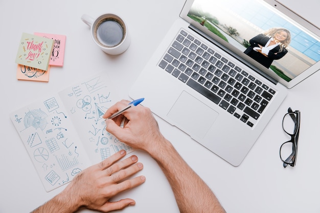 Workspace concept with hands drawing next to laptop