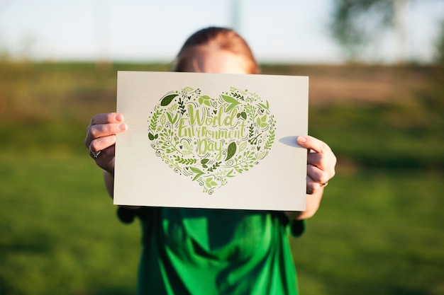 PSD world environment day mockup with volunteer holding paper