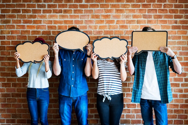 Young adults holding up copyspace placard thought bubbles