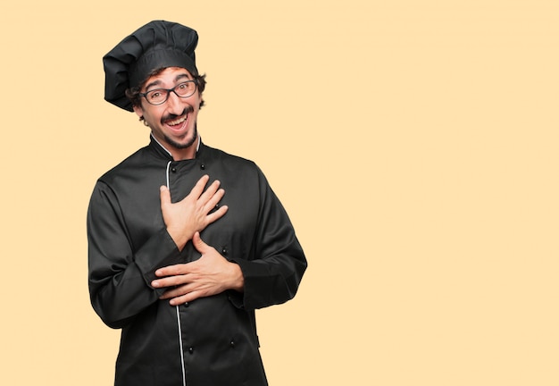 young crazy man as a chef Laughing out loud with head tilted backwards and happy, cheerful expression