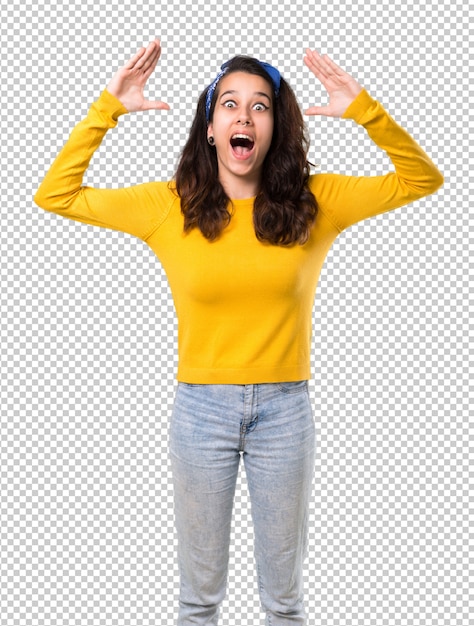 Young girl with yellow sweater and blue bandana on her head with surprise