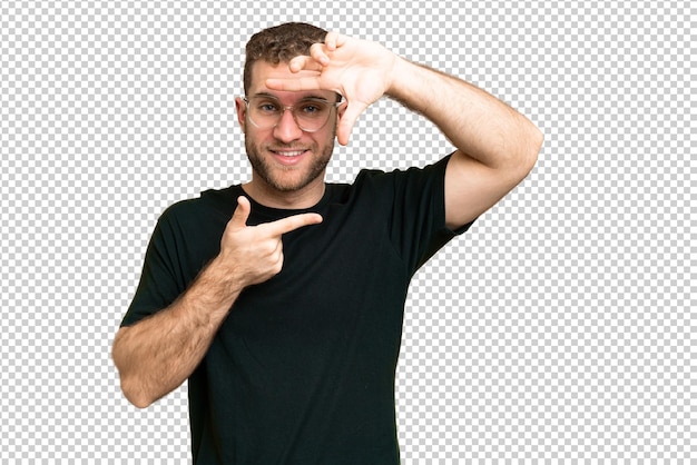 Young handsome blonde man over isolated chroma key background focusing face Framing symbol