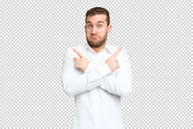 PSD young handsome blonde man over isolated chroma key background pointing to the laterals having doubts