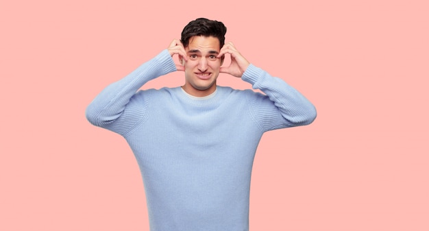 PSD young handsome man with a crazy, amazed look of surprise, holding head with both hands