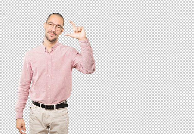 Young man doing a gesture of small size with his hand