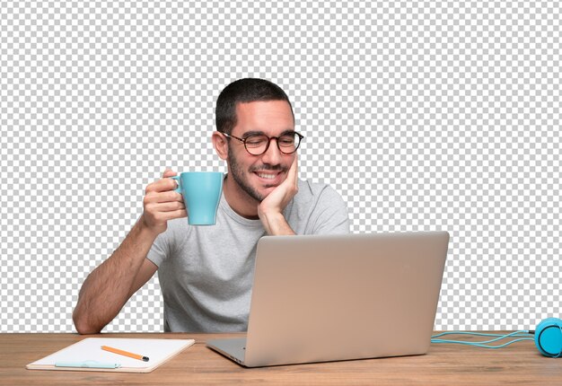 PSD young man sitting at his desk and drinking coffee