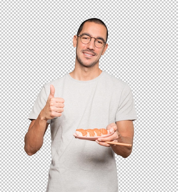 Young man using chopsticks to eat sushi