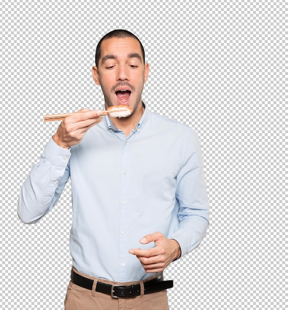 Young man using chopsticks to eat sushi