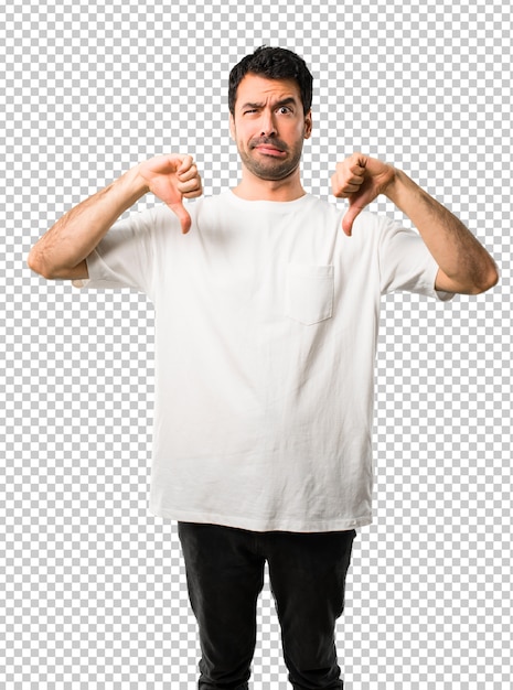 Young man with white shirt showing thumb down with both hands. Negative expression