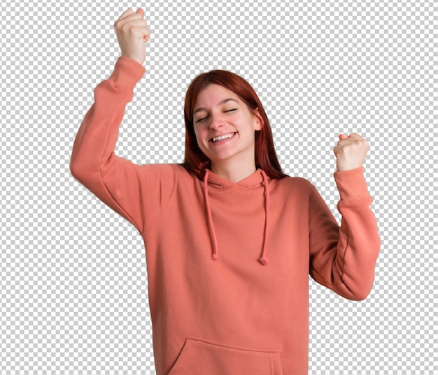 Young redhead girl with pink sweatshirt celebrating a victory and surprised to be successful