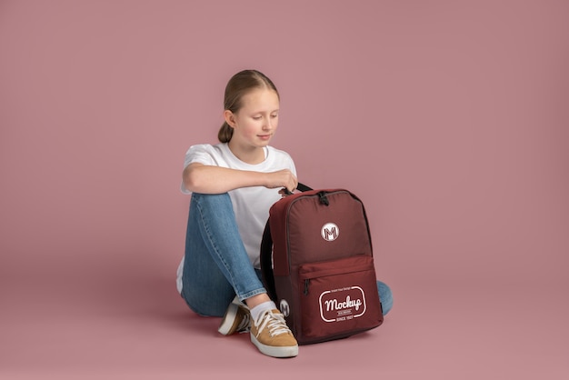 Young teenage girl carrying a backpack mock-up