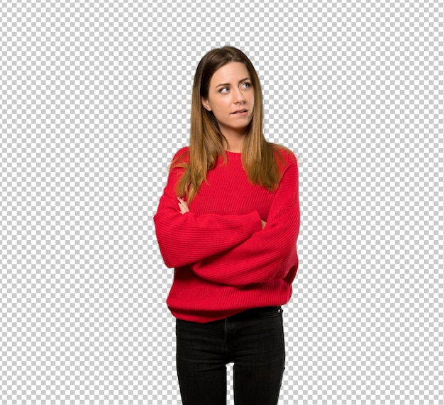 Young woman with red sweater with confuse face expression while bites lip